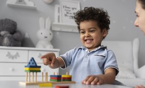 menininho apontando para brinquedo de montar em cima da mesa